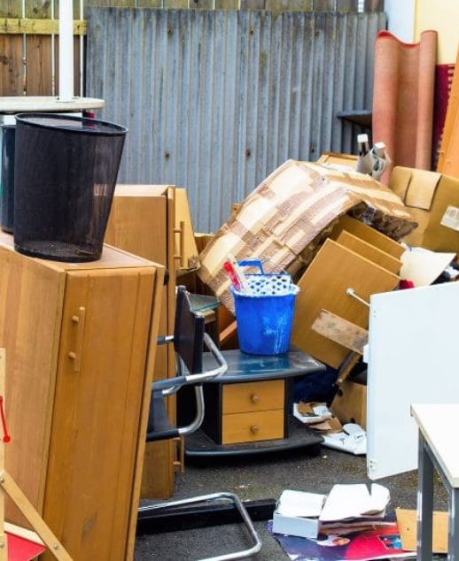 A cluttered yard filled with a pile of furniture and boxes, indicating a junk removal service in Chicago, IL.