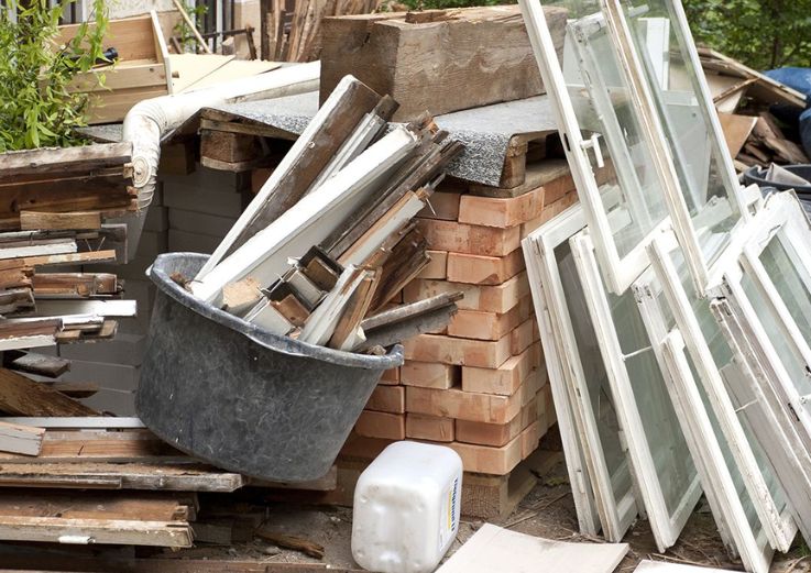 A collection of discarded windows and assorted items, representing a construction and renovation service in Chicago, IL.