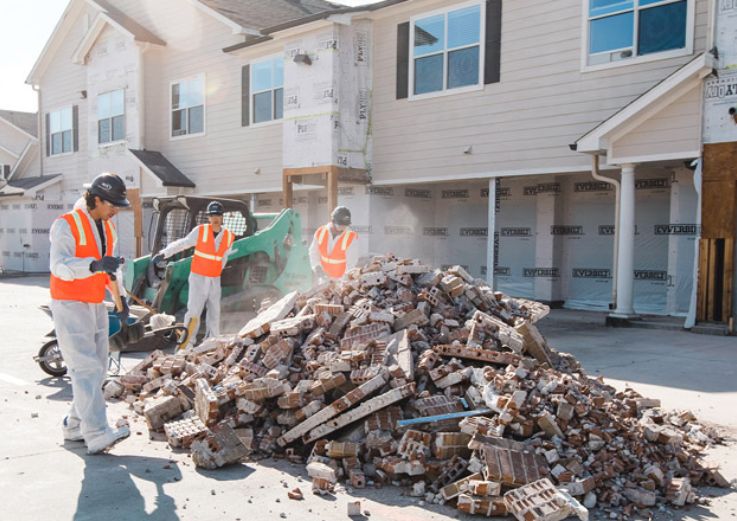 Workers handling bricks at a Chicago demolition site, showcasing construction efforts.