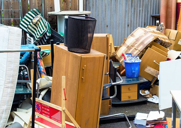 A cluttered yard displaying a heap of furniture and other items, illustrating the work of an indoor junk removal service in Chicago, IL.