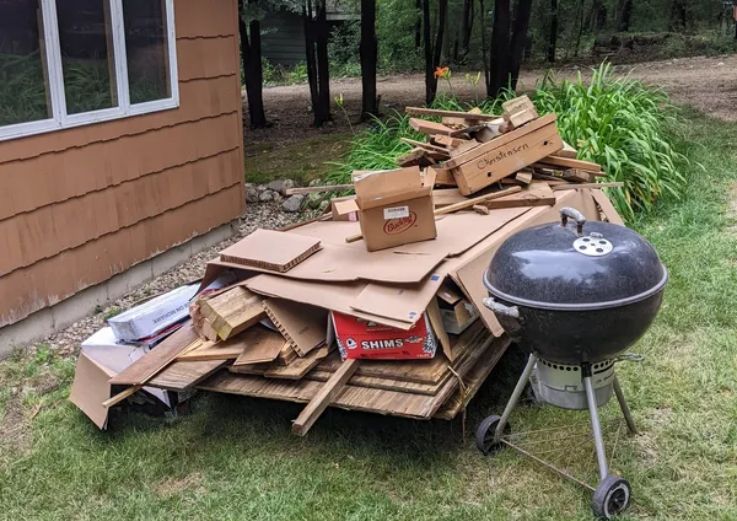 A yard featuring a pile of wood and a grill, highlighting outdoor junk removal services in Chicago, IL.